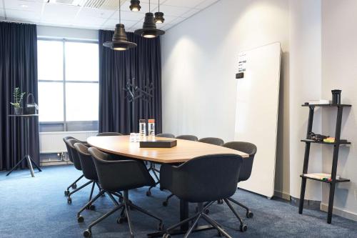 a conference room with a wooden table and chairs at Scandic Crown in Gothenburg