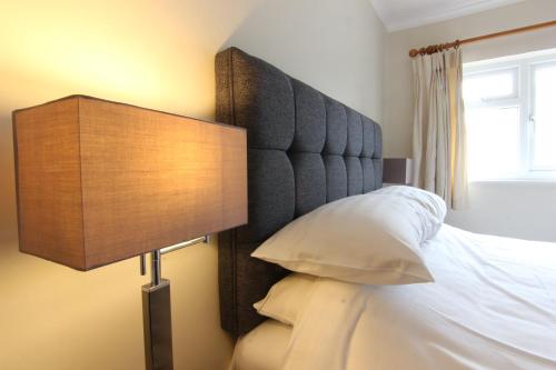 a bedroom with a bed with a headboard and a lamp at St. Davids Cross Hotel in St. Davids