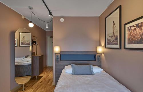a bedroom with a bed and a mirror at Scandic CH in Gävle