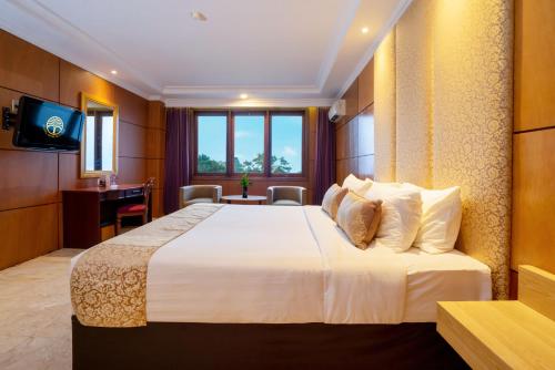 a hotel room with a large bed and a desk at Hotel Bumi Senyiur in Samarinda