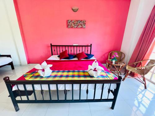 a bed in a room with a pink wall at New Blue Mount View Kandy in Kandy