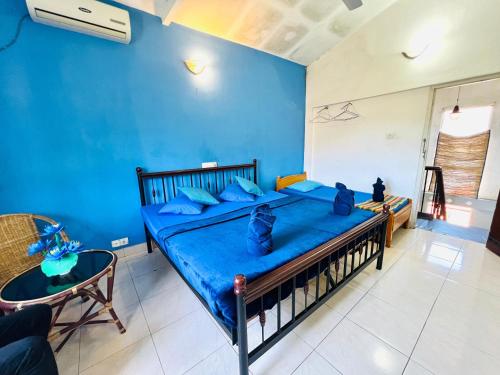 a blue bedroom with a bed with two cats sitting on it at New Blue Mount View Kandy in Kandy