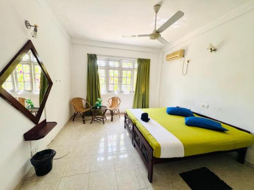 a bedroom with a bed and a mirror and a table at New Blue Mount View Kandy in Kandy