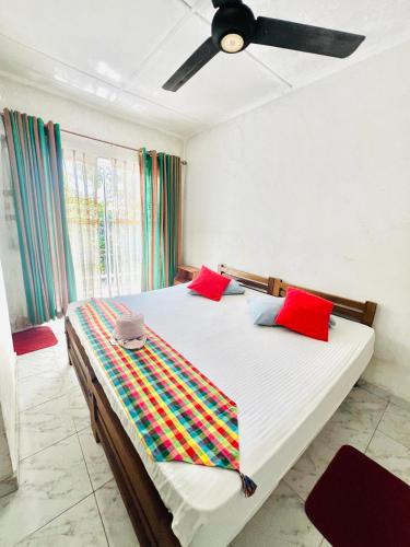 a bedroom with a bed with red and colorful pillows at New Blue Mount View Kandy in Kandy