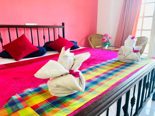 two stuffed animals are sitting on a bed at New Blue Mount View Kandy in Kandy