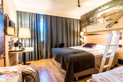 a hotel room with a bunk bed and a desk at Scandic Kalmar in Kalmar