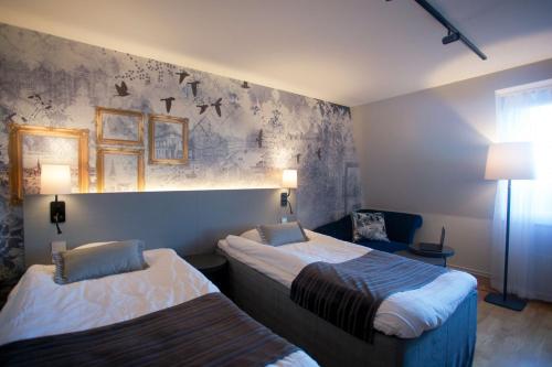 a hotel room with two beds and a couch at Scandic Winn in Karlstad