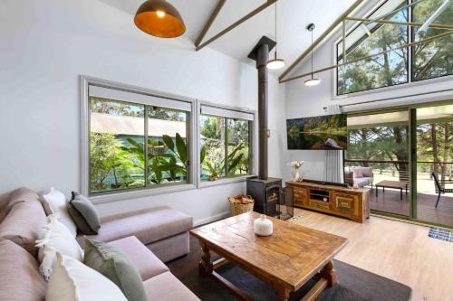 a living room with a couch and a table at Owl House in Kangaroo Valley