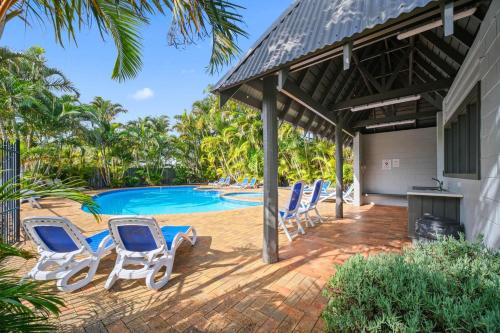 a patio with chairs and a swimming pool at Shores Beach & Lakeside Villas in Elizabeth Beach