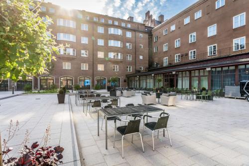 a courtyard with tables and chairs in front of a building at Scandic Frimurarehotellet in Linköping