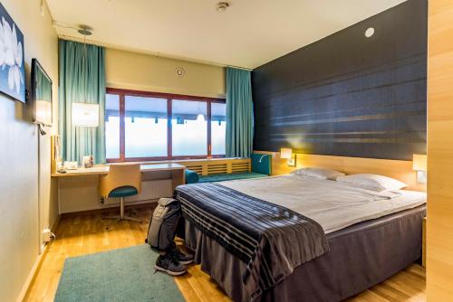 a hotel room with a large bed and a desk at Scandic Frimurarehotellet in Linköping