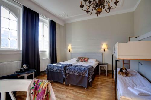 a bedroom with two beds and a table and chairs at Scandic Frimurarehotellet in Linköping