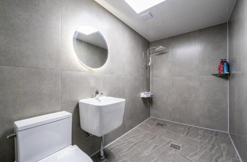 a bathroom with a toilet and a sink and a mirror at Moonstay Hotel Cheonan in Cheonan