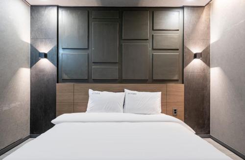 a bedroom with a large white bed with two lights at Moonstay Hotel Cheonan in Cheonan