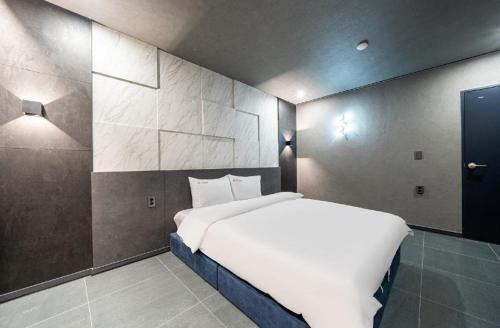 a bedroom with a large white bed in a room at Moonstay Hotel Cheonan in Cheonan