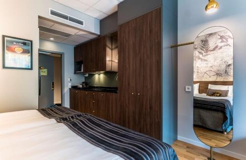 a bedroom with a large bed and a kitchen at Scandic Frimurarehotellet in Linköping