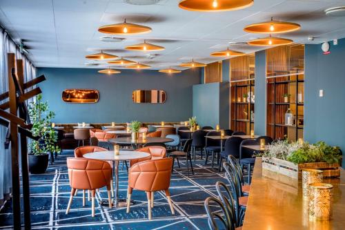 a restaurant with tables and chairs and bookshelves at Scandic Frimurarehotellet in Linköping