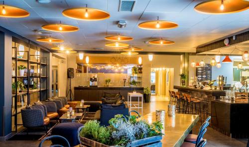 a restaurant with tables and chairs and a bar at Scandic Frimurarehotellet in Linköping