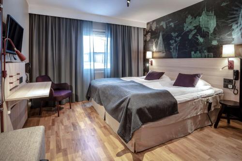a hotel room with a bed and a desk at Scandic Linköping Väst in Linköping