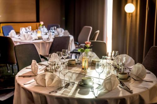 a set of tables with white tablecloths and napkins at Scandic Frimurarehotellet in Linköping