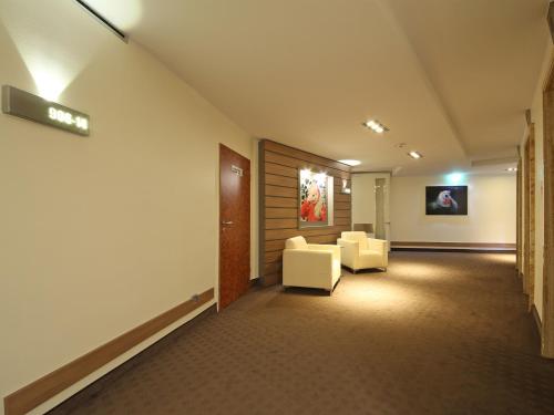 a hallway with two chairs and a waiting room at Congress Hotel am Stadtpark in Hannover
