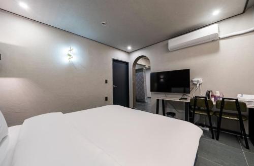 a bedroom with a bed and a desk and a television at Moonstay Hotel Cheonan in Cheonan