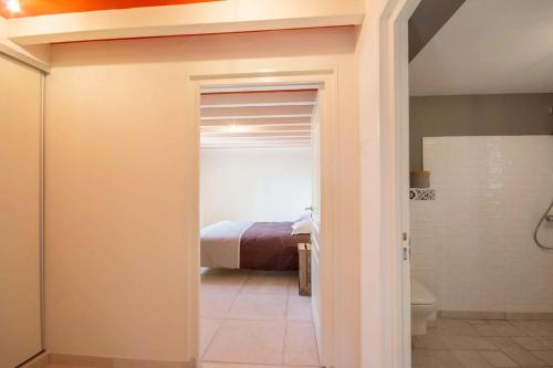 a bedroom with a bed and a bathroom with a toilet at Le pressoir in Guidel
