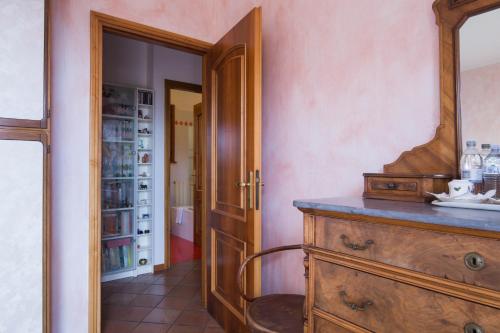 Cette chambre comprend une commode en bois et un miroir. dans l'établissement B&B La Mimosa del Golfo, à Ospedaletti