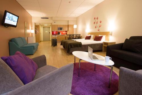 a hotel room with a bed and a couch and a table at Scandic Malmö City in Malmö