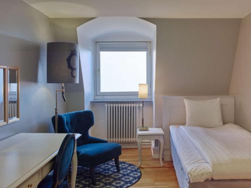 ein Schlafzimmer mit einem Bett und einem Stuhl und einem Fenster in der Unterkunft Scandic Kramer in Malmö