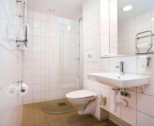 a bathroom with a toilet and a sink and a shower at Scandic Malmö City in Malmö