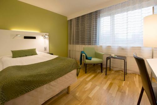 a bedroom with a bed and a table and chairs at Scandic S:t Jörgen in Malmö