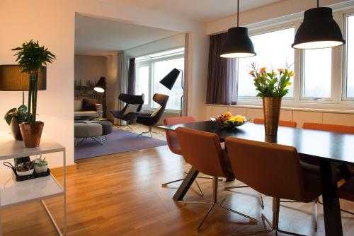 a dining room and living room with a table and chairs at Scandic S:t Jörgen in Malmö