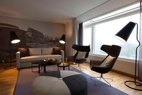 a living room with a couch and chairs and a large window at Scandic S:t Jörgen in Malmö