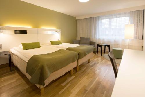 a hotel room with two beds and a table at Scandic S:t Jörgen in Malmö
