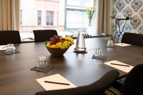 a wooden table with a bowl of fruit on it at Scandic S:t Jörgen in Malmö