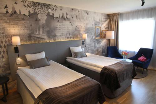 a hotel room with two beds and a chair at Scandic Triangeln in Malmö