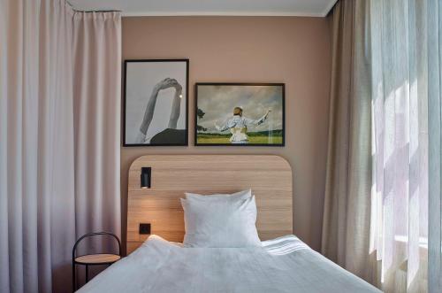 a bedroom with a bed with two pictures on the wall at Scandic Strömmen in Norrköping