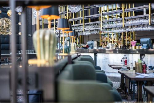 a bar with green chairs in a restaurant at Scandic Triangeln in Malmö