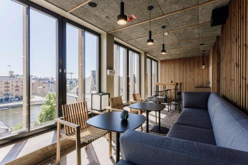 a room with tables and a couch and windows at Scandic Strömmen in Norrköping