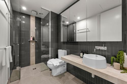 a bathroom with a toilet and a sink and a shower at Restful CBD Park Views Retreat in Melbourne
