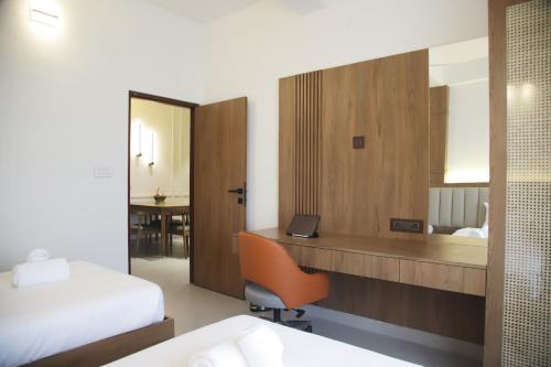a hotel room with a desk and a bed and a mirror at Hunkal Stays in Chikmagalūr
