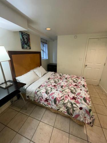 a bedroom with a bed and a lamp and a table at Linda guesthouse in Vancouver