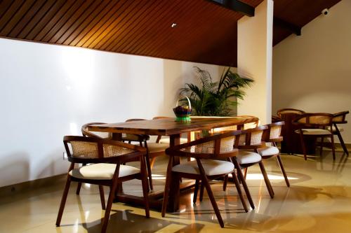 a dining room with a wooden table and chairs at Hunkal Stays in Chikmagalūr