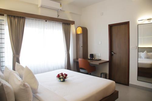 a hotel room with a bed with flowers on it at Hunkal Stays in Chikmagalūr