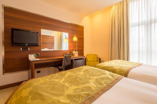 a hotel room with two beds and a desk at Best Western Premier BHR Treviso Hotel in Quinto di Treviso