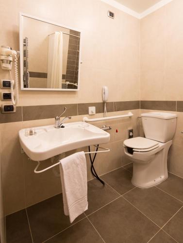 a bathroom with a sink and a toilet and a mirror at Best Western Premier BHR Treviso Hotel in Quinto di Treviso