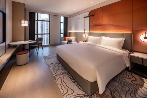 Postel nebo postele na pokoji v ubytování Grand Mercure Yichang Waitan