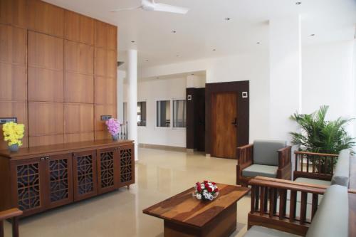 a lobby with a couch and a chair and a table at Hunkal Stays in Chikmagalūr