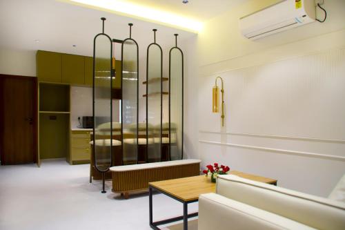 a living room with a table and a kitchen at Hunkal Stays in Chikmagalūr